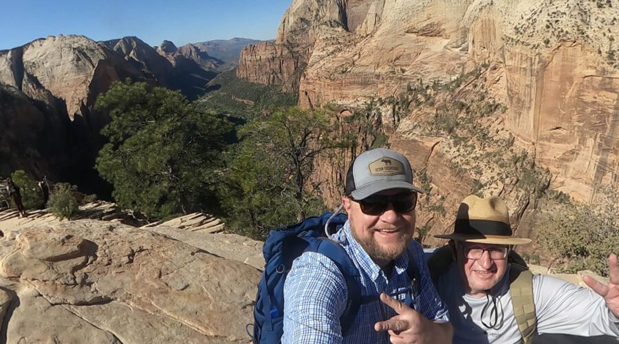 A guide and guest pose for a photo at the top of Angel's Landing in Zion National Park, Utah. Taken on a Teton Excursions tour of Utah's Mighty 5 National Parks.