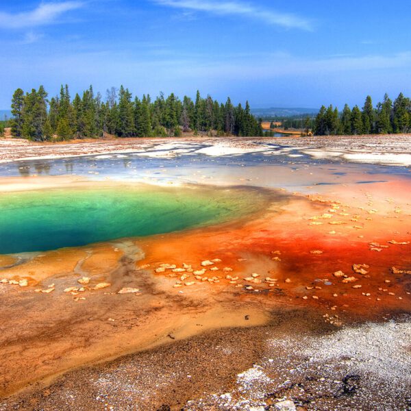 Hot Spring pool in Yellowstone National Park. A couple watches as Old Faithful geyser erupts in Yellowstone National Park. Taken on a Teton Excursions tour of Yellowstone National Park.